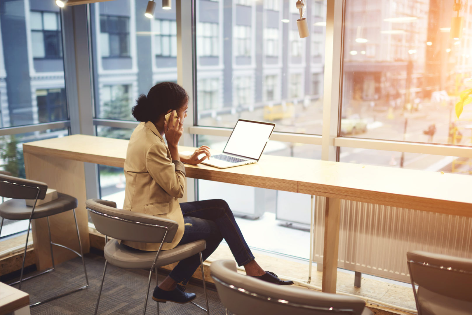 Cloud Computing girl on phone sitting with laptop at bar